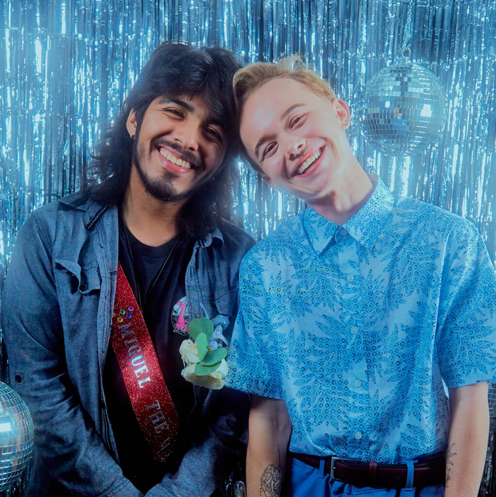 two people smiling in front of blue background